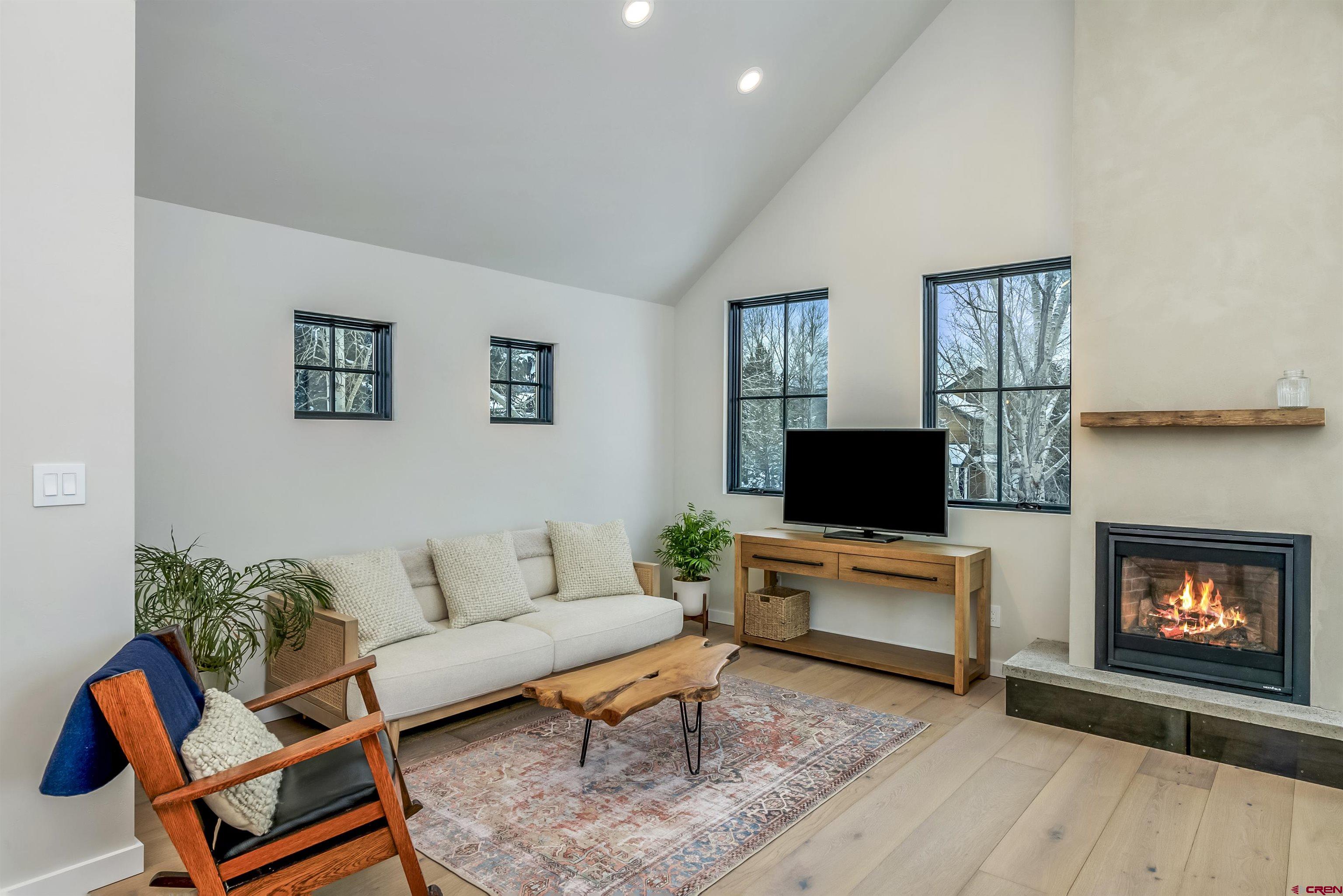 705 9th Street Crested Butte, CO 81224 - Photo 33 of 44 a living room with furniture a fireplace and a flat screen tv