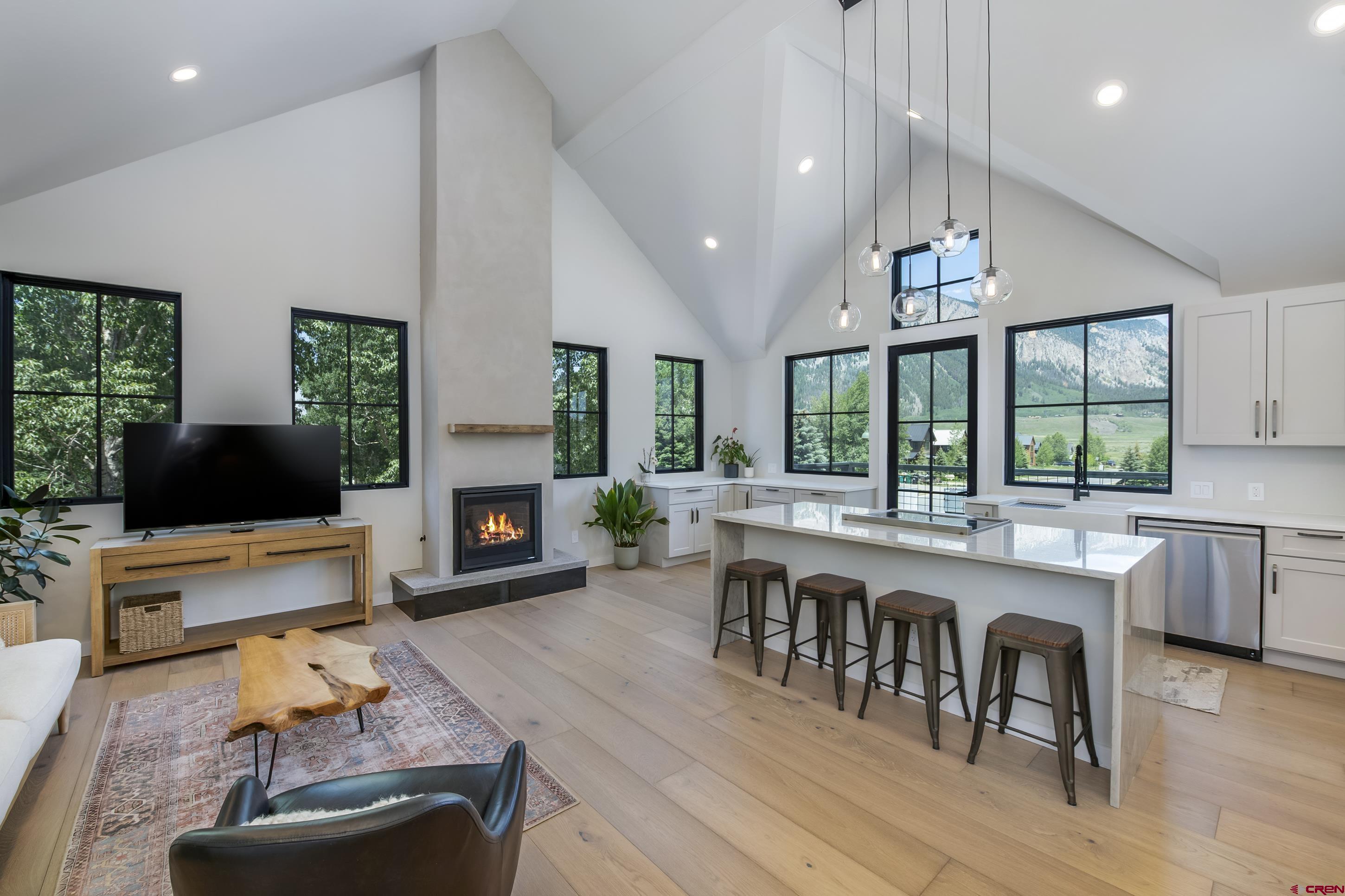 705 9th Street Crested Butte, CO 81224 - Photo 4 of 44 a living room with furniture a fireplace a flat screen tv and a large window