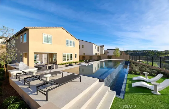 a view of a house with pool and chairs
