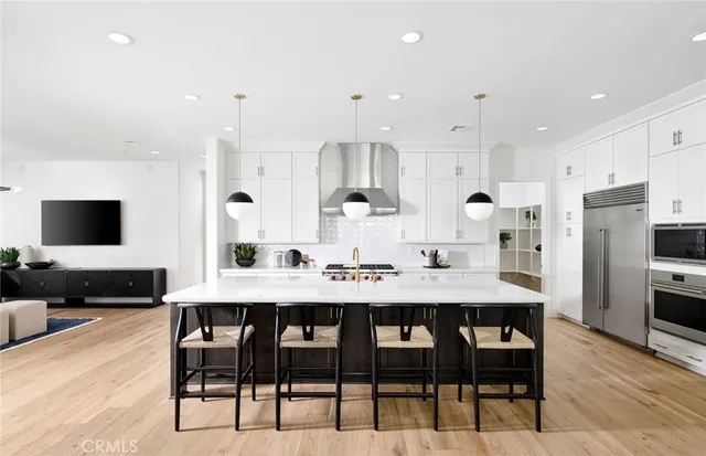 a kitchen with stainless steel appliances kitchen island granite countertop a table and chairs in it