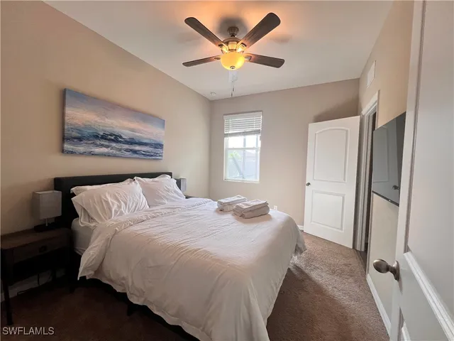 a spacious bedroom with a bed and a chandelier