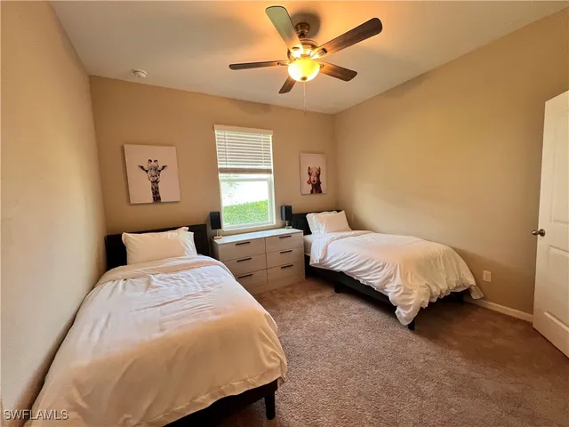a bedroom with two beds and a chandelier