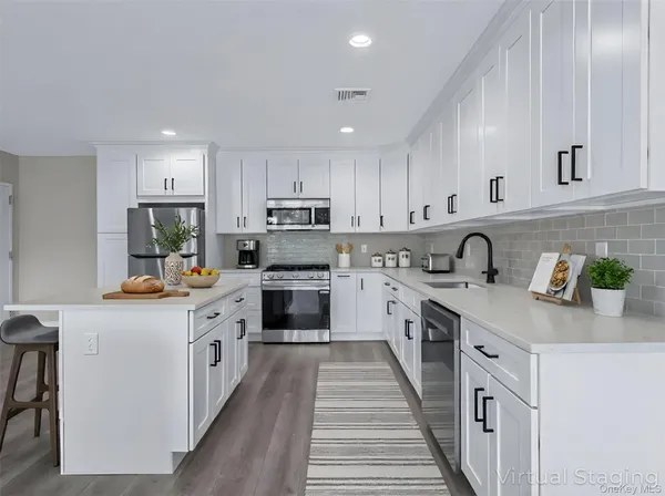 a kitchen with granite countertop white cabinets and white appliances