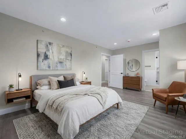 a spacious bedroom with a bed and a chair