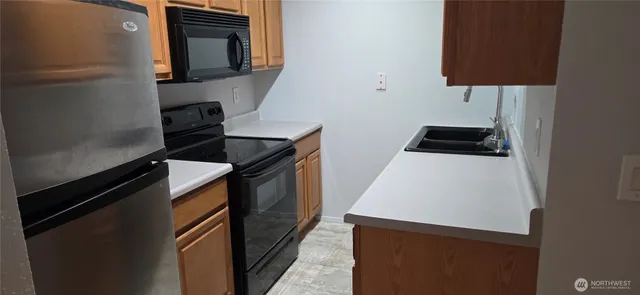 a kitchen with granite countertop a sink stove and refrigerator