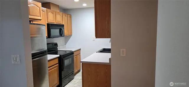 a kitchen with stainless steel appliances granite countertop a stove a sink and a microwave