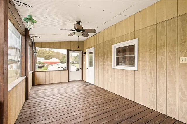 a view of a balcony with wooden floor and windows