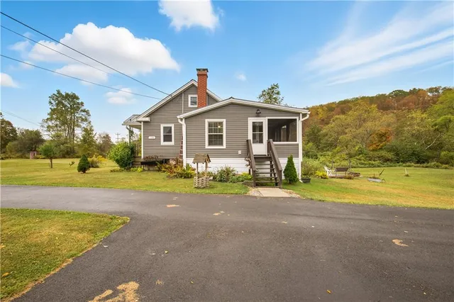 a view of a house with a yard and a large tree