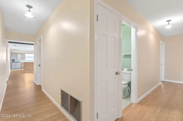 a view of a hallway with wooden floor