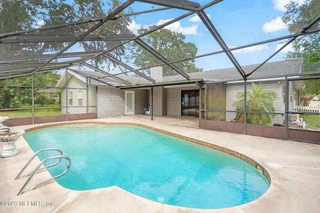 a swimming pool with outdoor seating and yard