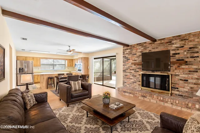a living room with furniture a flat screen tv and a fireplace