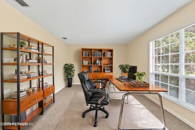 a view of a workspace with furniture and a window