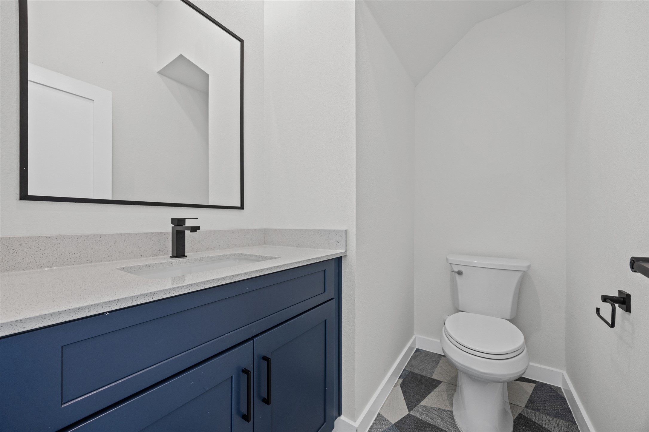 2000 Riverside Farms Road, Unit 5102 Austin, TX 78741 - Photo 7 of 25 A well-lit bathroom showcases a dark blue vanity with a modern black faucet and geometric patterned tile flooring.