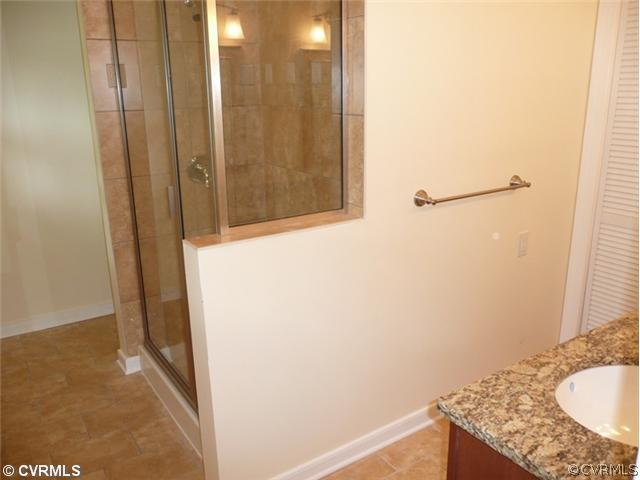 8127 Lethbridge Road Richmond, VA 23235 - Photo 6 of 12 Master Bath - What a Retreat! Offering Ceramic Tile Floors, Glass enclosed Ceramic Tile Shower with Custom Frame, Granite Double Vanity Brushed Nickel Fixtures, New Raised Panel Cabinets, New Lighting, New Plumbing, New Custom Mirrors & Newly Painted! Relax and Unwind.