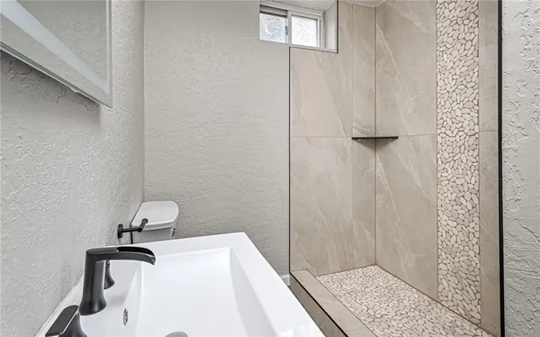 a bathroom with a sink a toilet and shower