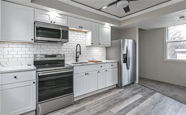 a kitchen with stainless steel appliances a stove microwave and refrigerator