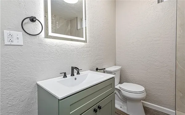 a bathroom with a toilet a sink and a mirror