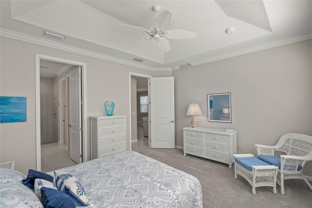 8605 Rain Song Road Sarasota, FL 34238 - Photo 18 of 52 a bedroom with a bed and a chandelier