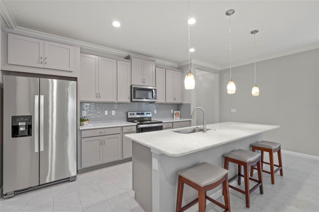 8605 Rain Song Road Sarasota, FL 34238 - Photo 6 of 52 a kitchen with stainless steel appliances a sink a stove a refrigerator cabinets and a table