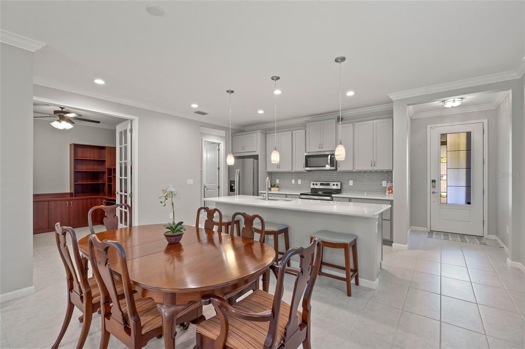 8605 Rain Song Road Sarasota, FL 34238 - Photo 10 of 52 a kitchen with a dining table chairs and refrigerator