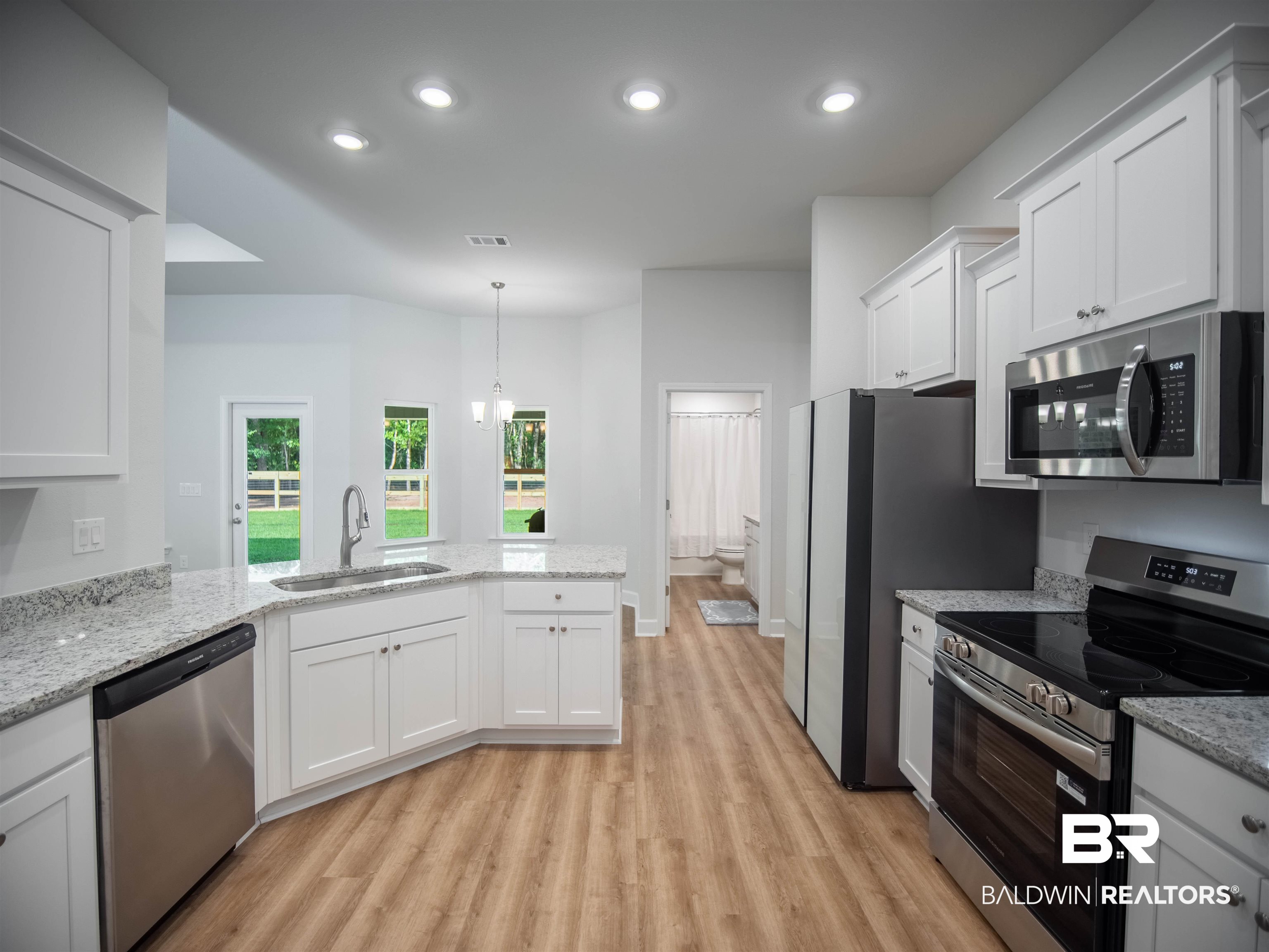 12646 Michigan Avenue Elberta, AL 36530 - Photo 12 of 47 Kitchen with stainless steel appliances, light wood-style floors, white cabinets, a peninsula, and recessed lighting
