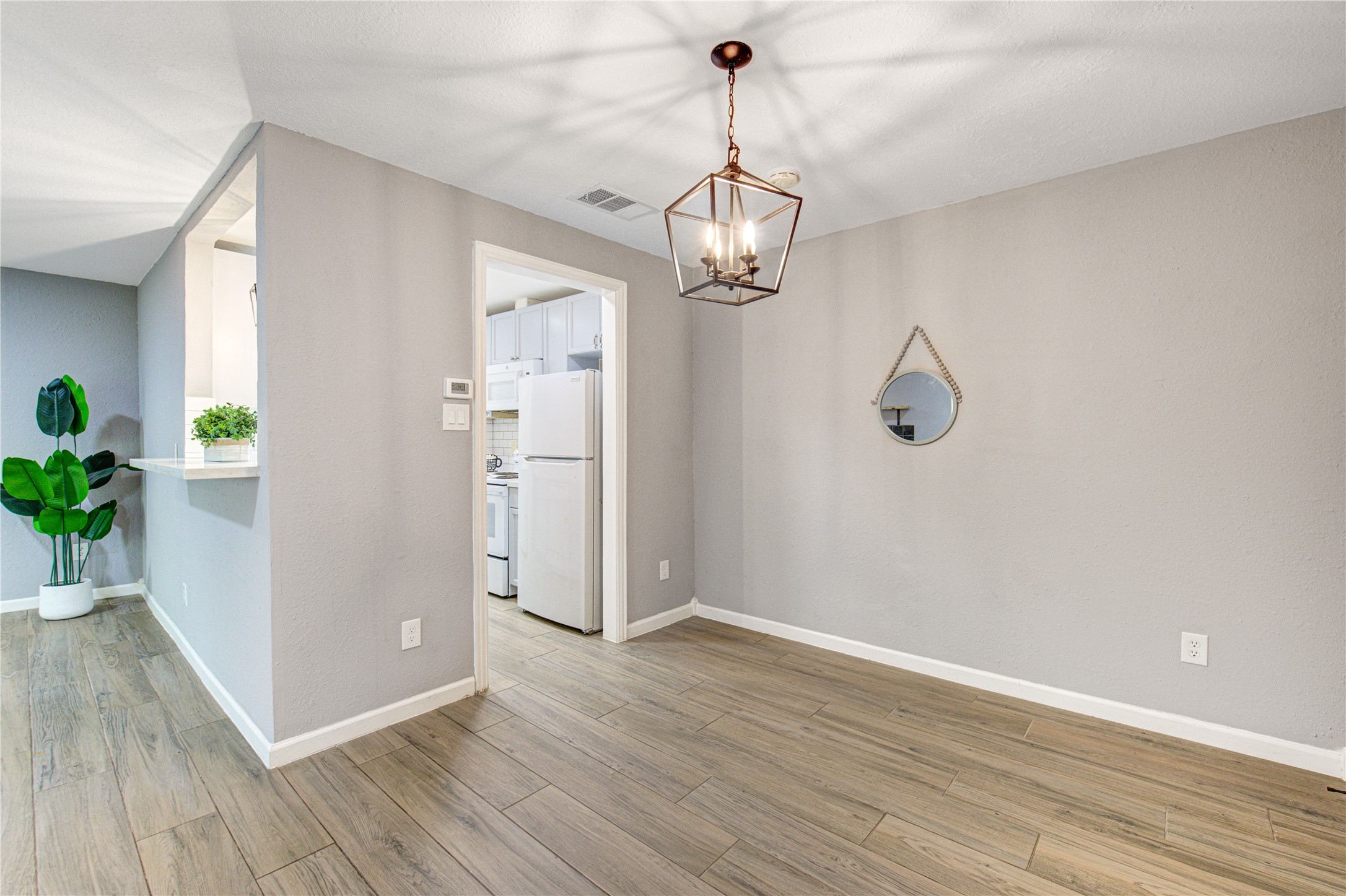 3929 Tanglewilde Street, Unit 3929 Houston, TX 77063 - Photo 19 of 44 a view of a hallway with wooden floor and a chandelier