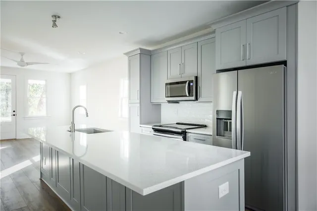 a kitchen with stainless steel appliances a refrigerator sink and cabinets