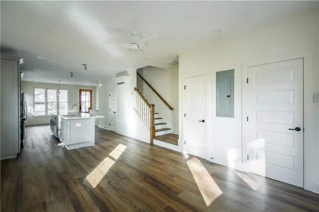 a view of a living hall with wooden floor and a kitchen