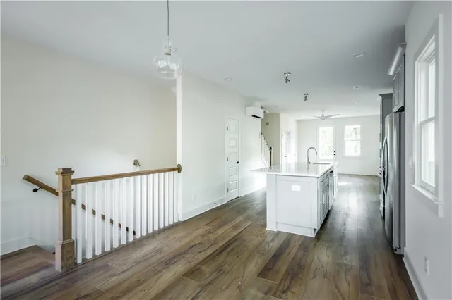 a view of a kitchen and an empty room with wooden floor