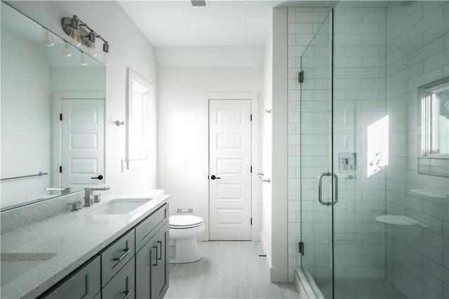 a bathroom with a double vanity sink toilet and shower