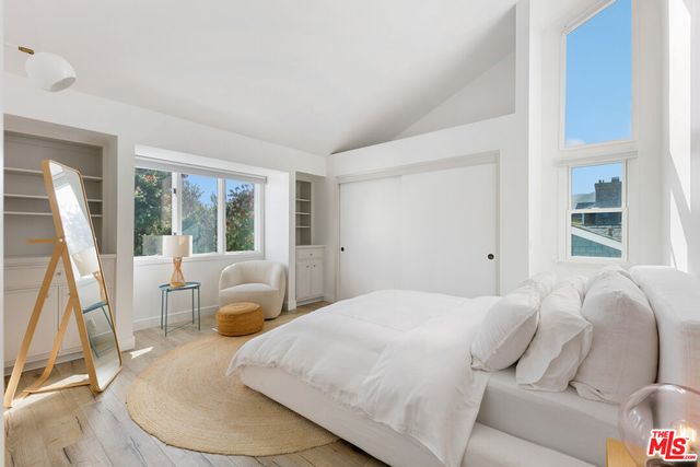 a bedroom with a bed window and chair