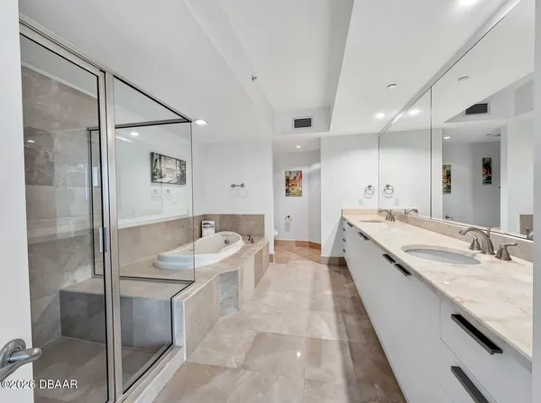 a large bathroom with a granite countertop sink mirror and a bathtub
