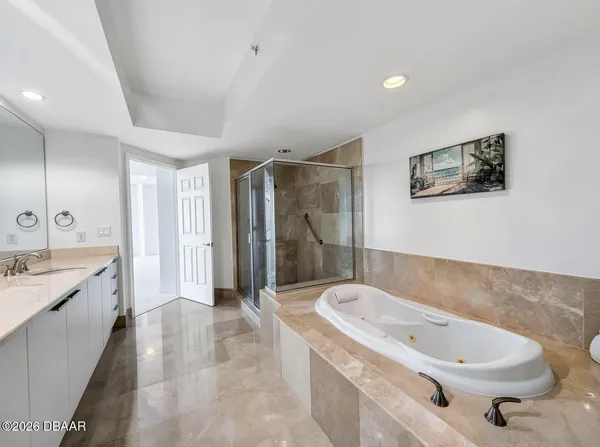 a bathroom with a tub a sink and mirror
