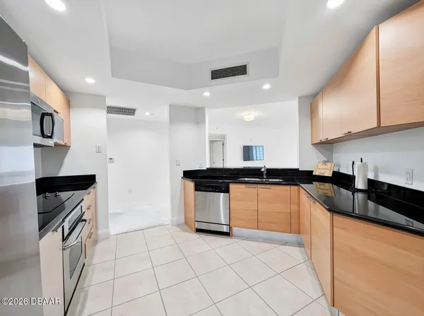 a kitchen with stainless steel appliances granite countertop a sink and a stove