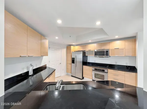 a kitchen with stainless steel appliances a stove a sink and cabinets