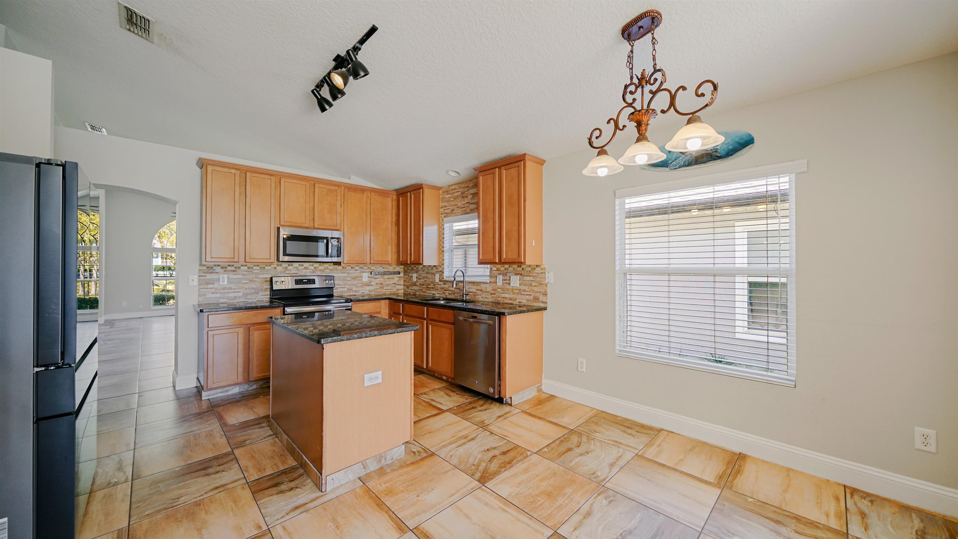 617 Birchbark Trail St. Augustine, FL 32092 - Photo 9 of 41 a kitchen with kitchen island granite countertop stainless steel appliances a stove a sink cabinets and a window