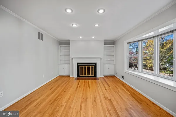 a view of an empty room with a fireplace and window
