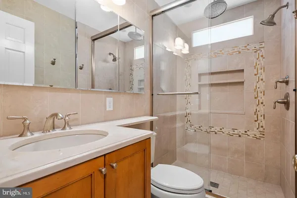 a bathroom with a sink a toilet and shower