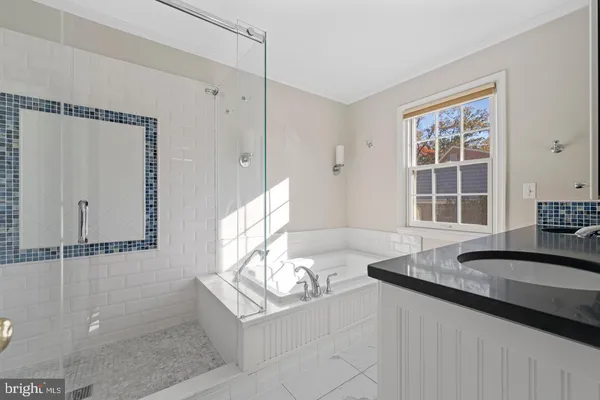 a bathroom with a granite countertop sink and a window
