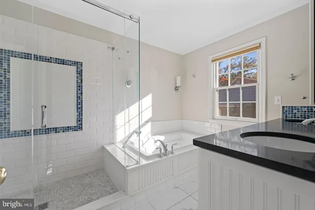 a bathroom with a granite countertop sink and a window