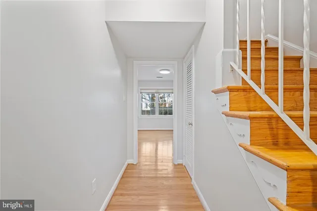 a view of a hallway with wooden floor and staircase