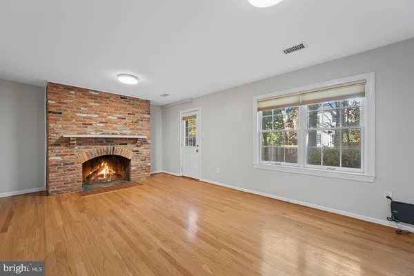 a view of an empty room with a window and fireplace
