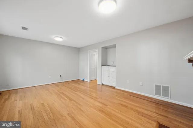 a view of empty room with wooden floor
