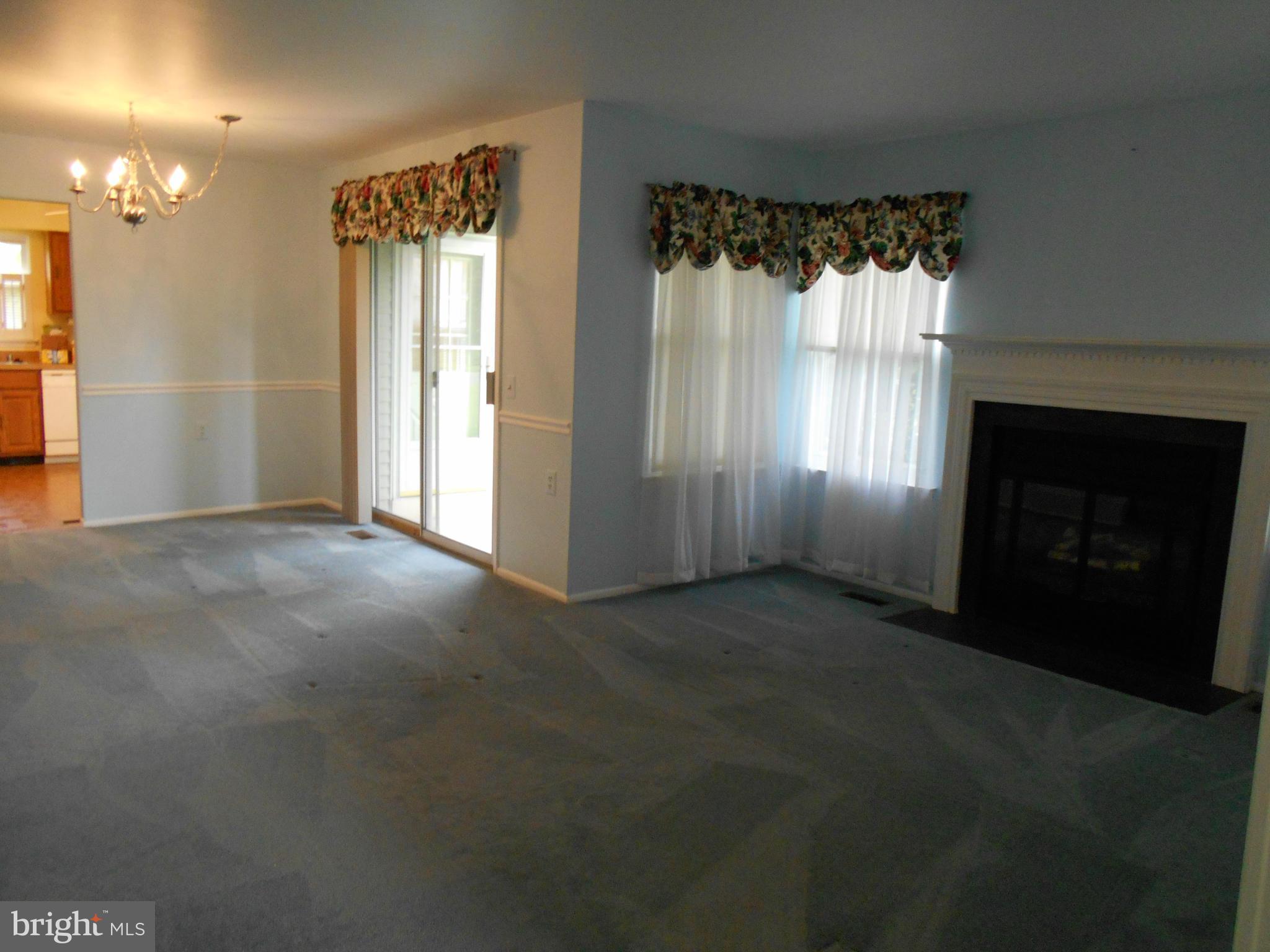 7048 Catalpa Road Frederick, MD 21703 - Photo 3 of 26 a view of an empty room with a fireplace and a window