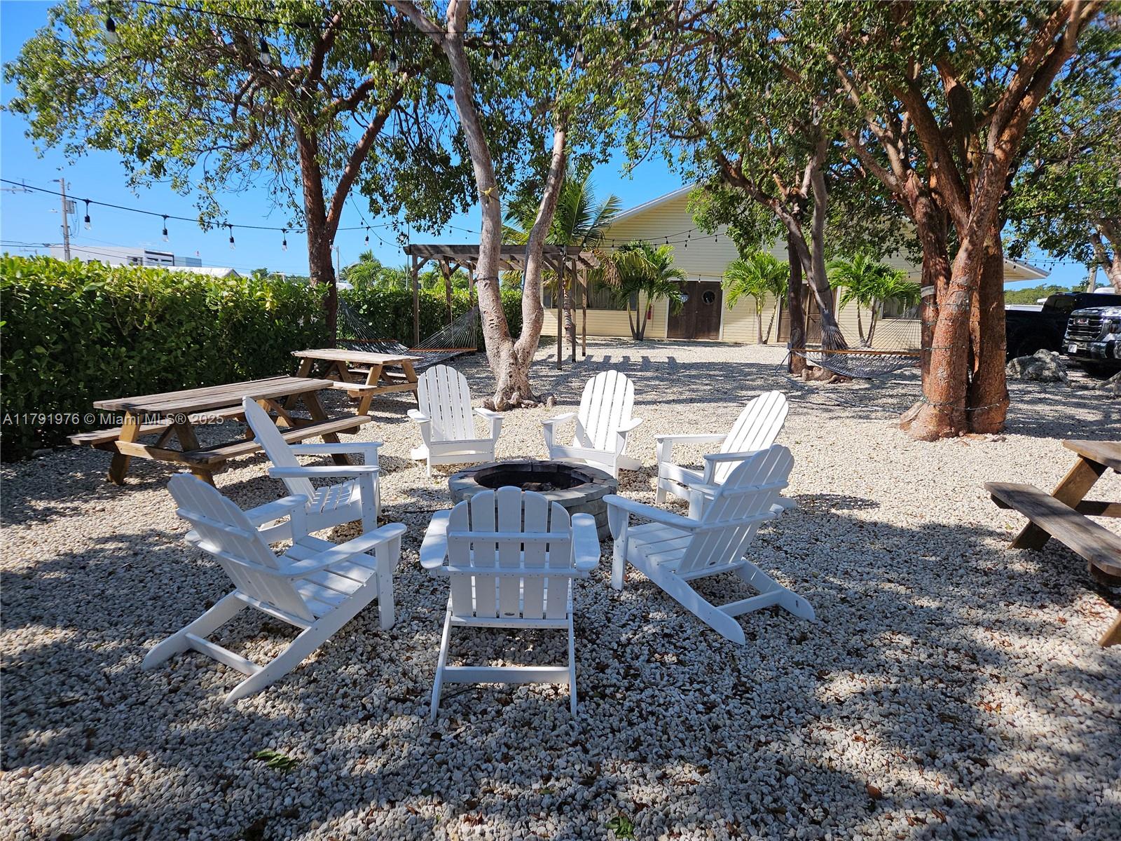 325 Calusa Street Key Largo, FL 33037 - Photo 34 of 48 a view of a backyard with table and chairs and a fire pit