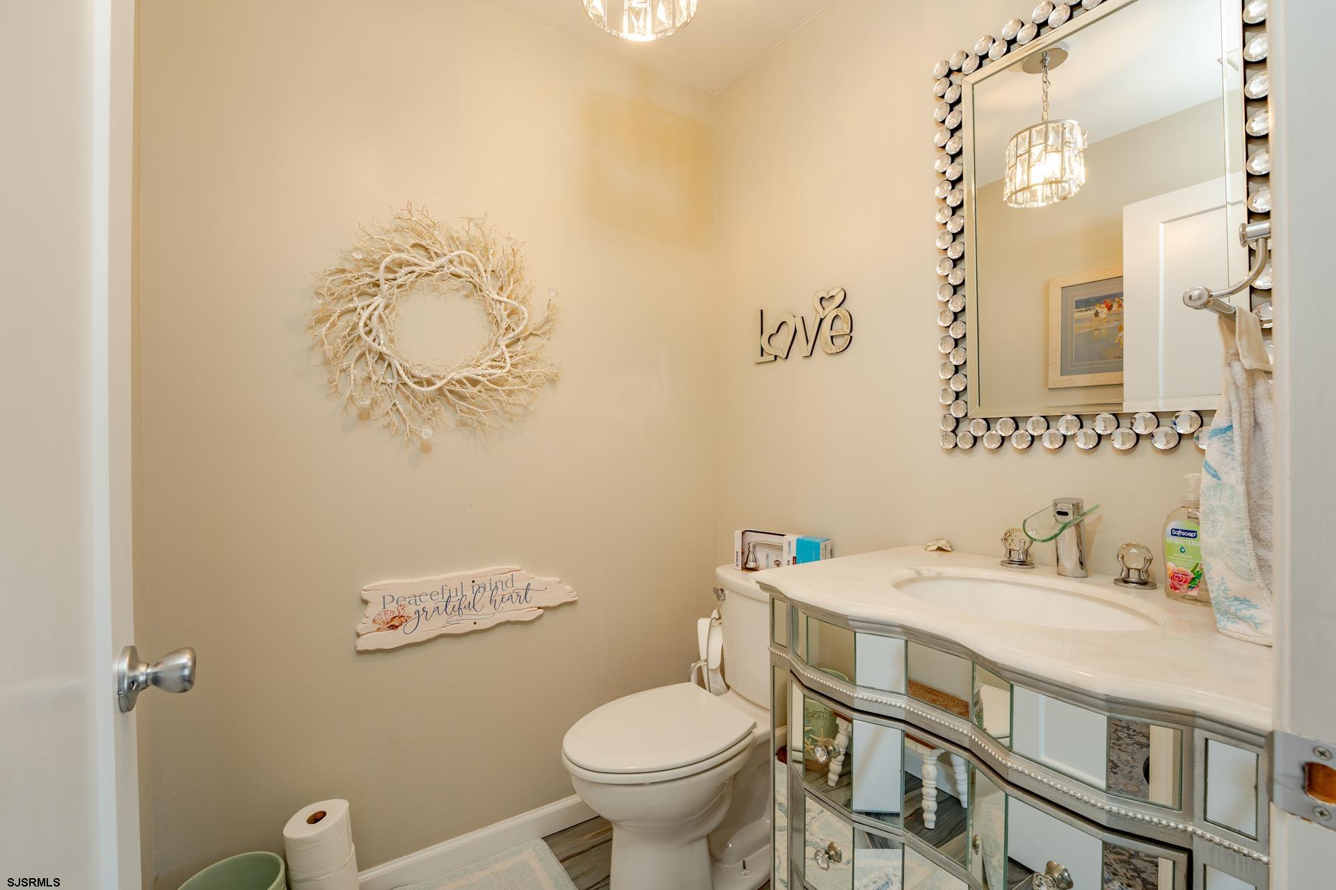 703 Bobby Jones Road Brigantine, NJ 08203 - Photo 20 of 34 a bathroom with a sink mirror vanity and toilet