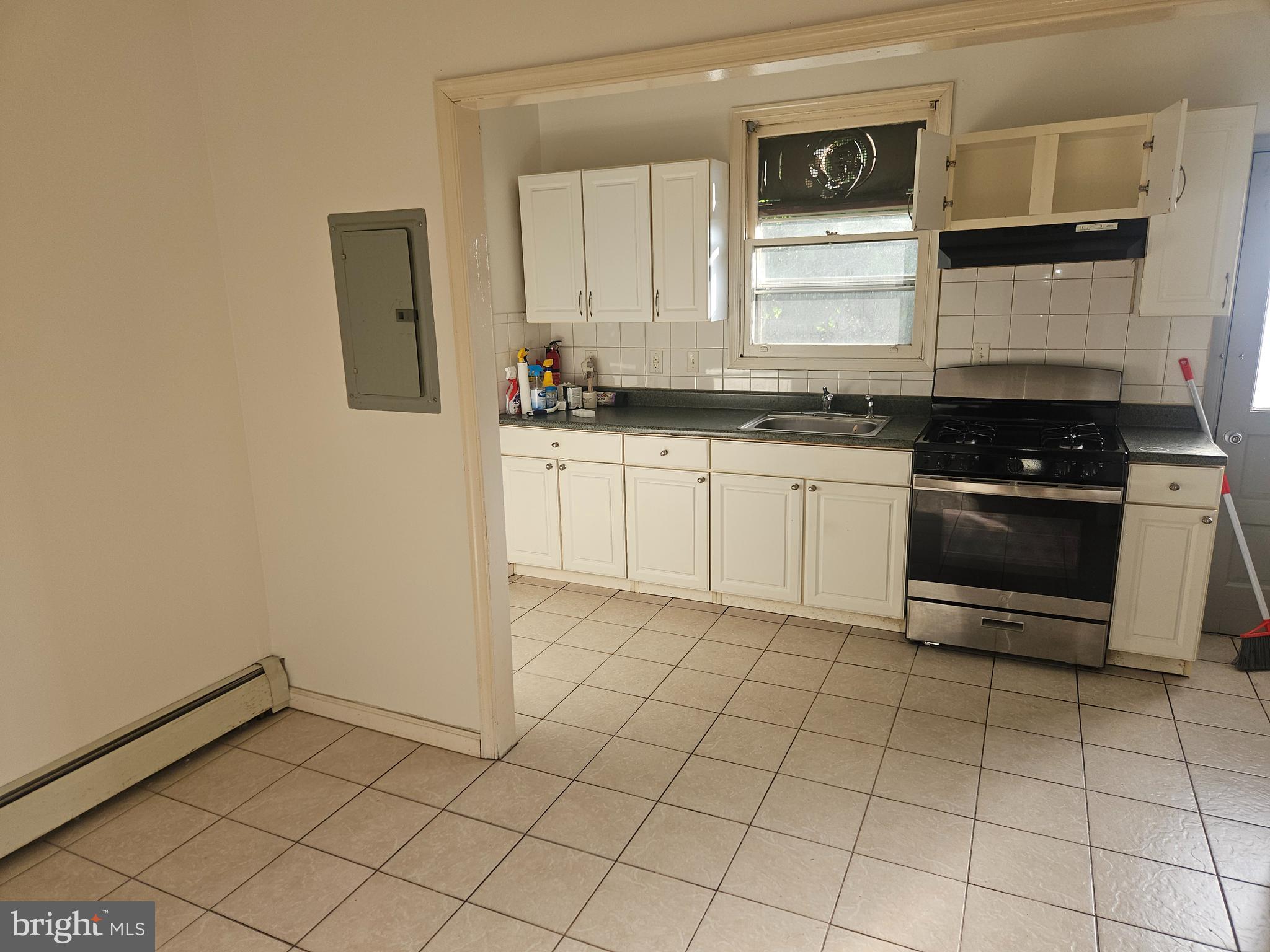 106 North 11th Street Pottsville, PA 17901 - Photo 5 of 6 a kitchen with a stove a sink and a microwave