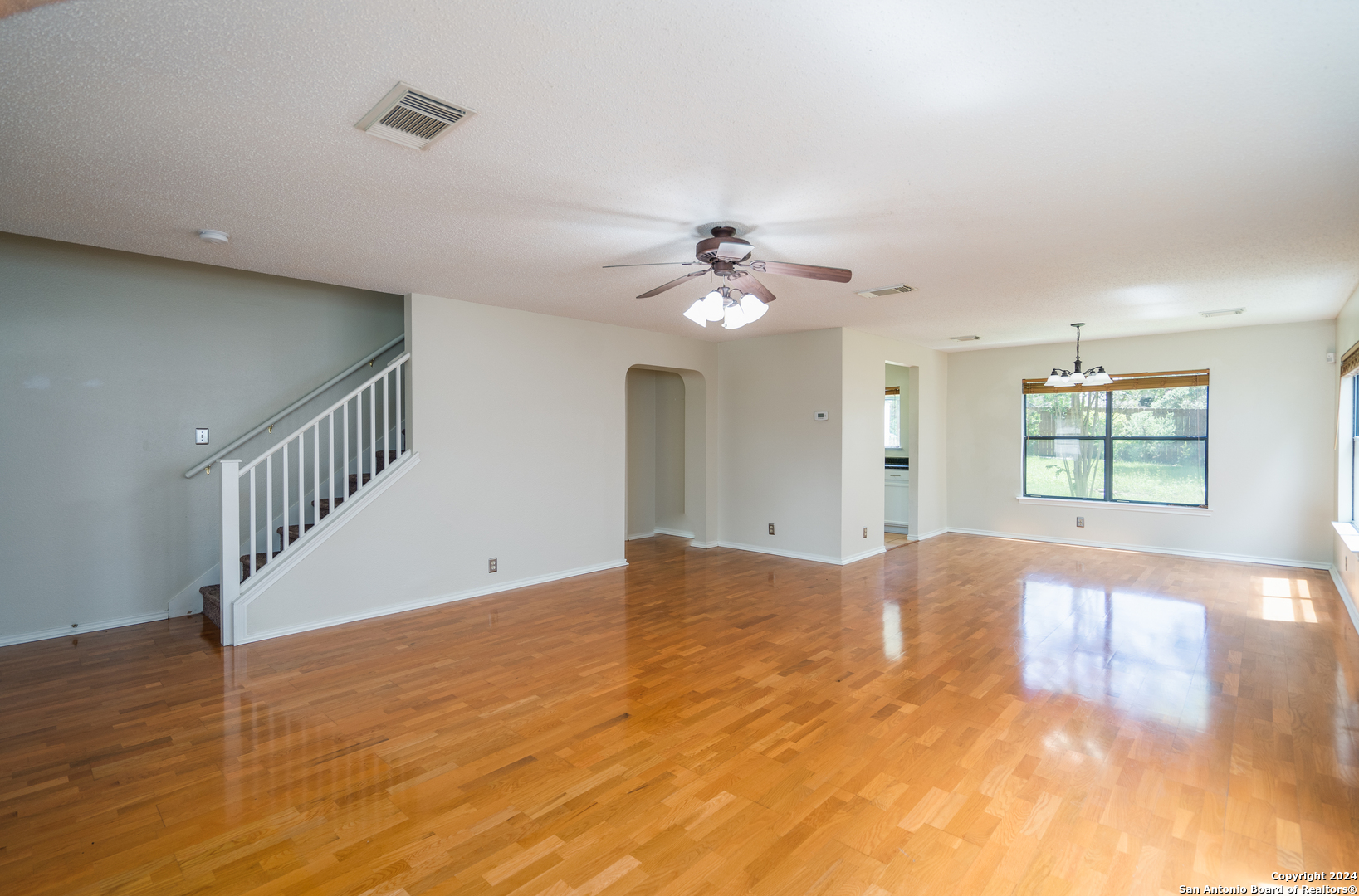 9243 Windward Trace San Antonio, TX 78254 - Photo 13 of 24 a view of an empty room with wooden floor and a chandelier