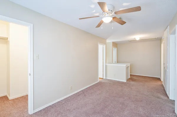 a view of an empty room and a ceiling fan