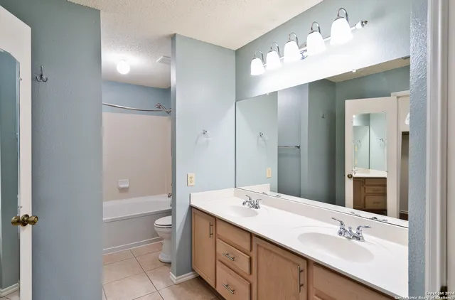 a bathroom with a double vanity sink mirror and toilet